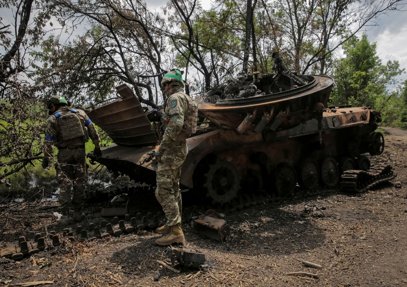Ukrainian soldiers in front of a destroyed Russian BMP-2
